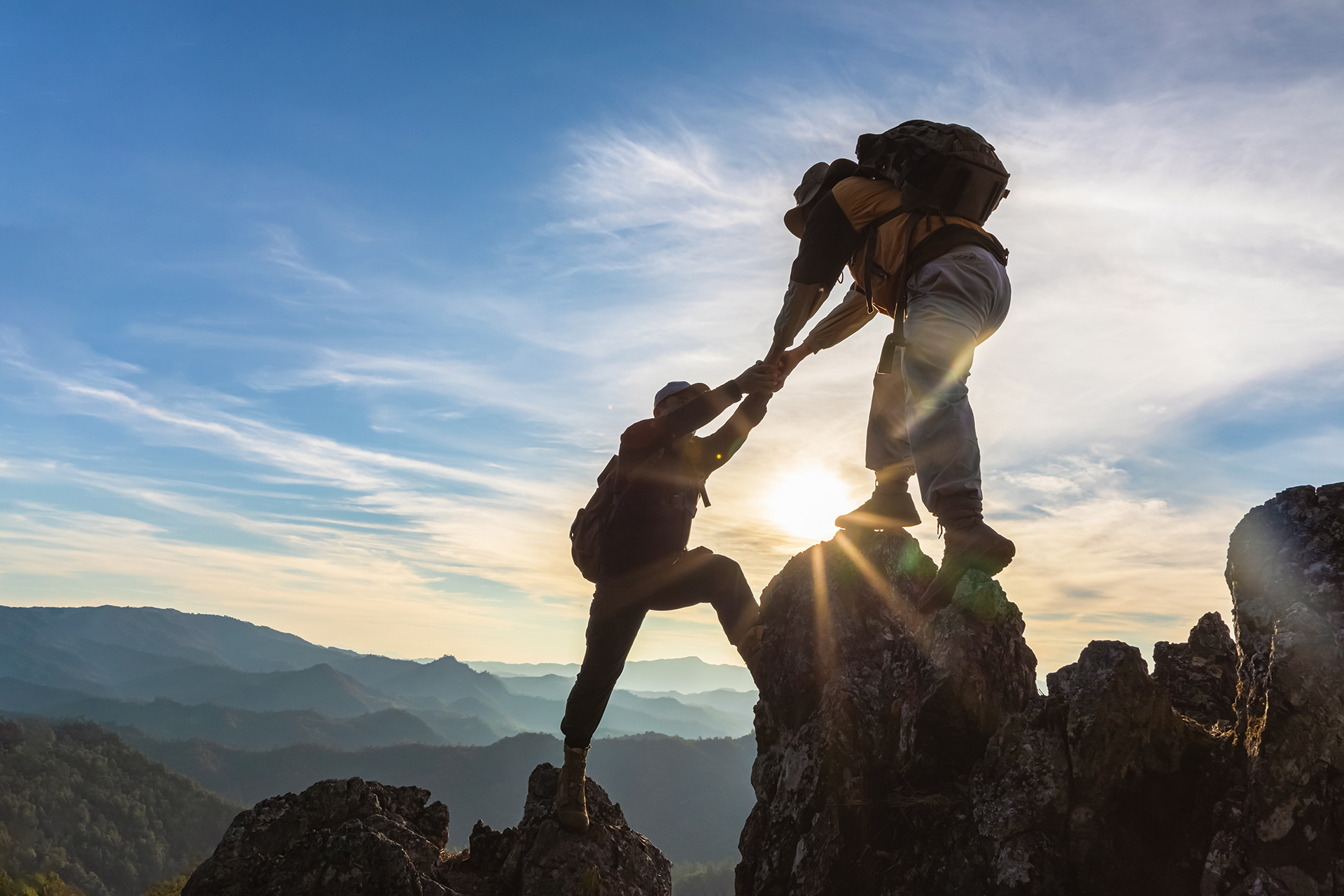 Silhouette,Two,Male,Hikers,Climbing,Up,Mountain,Cliff,And,One